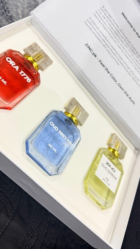 Customer displays the OUD Supreme BUNDLE with its three colorful perfume bottles inside the white box.