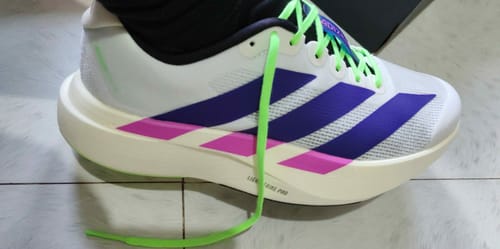 Customer's white adidas Adizero EVO SL shoe with purple stripes and vibrant lime green laces, shown from the side.