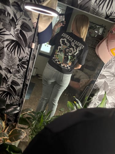 Reviewer in a mirror selfie showing the back graphic of the black Sunday Scaries T-Shirt.