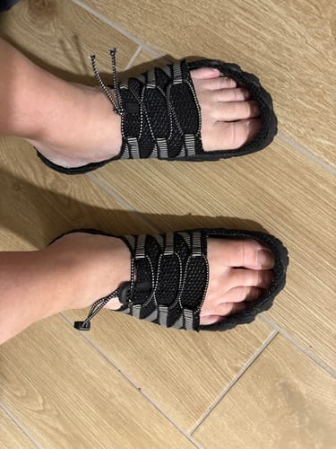 Asiakkaan jalassa muokatut Vapauta Varpaat™ -paljasjalkakengät, joista on tehty lipokkaat leikkaamalla verkko-osa pois.