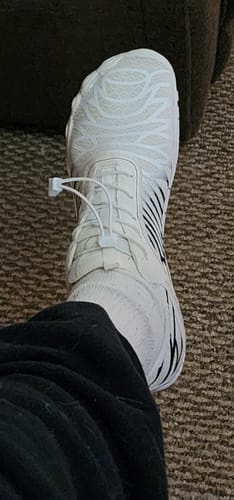 Customer's foot wearing the white, flexible Lorax Pro barefoot shoe, seen from an overhead angle.