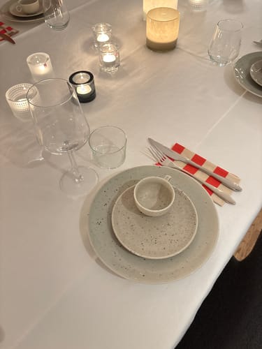 Kundens Dotty-assiett på ett vackert dukat bord med glas och tända ljus.