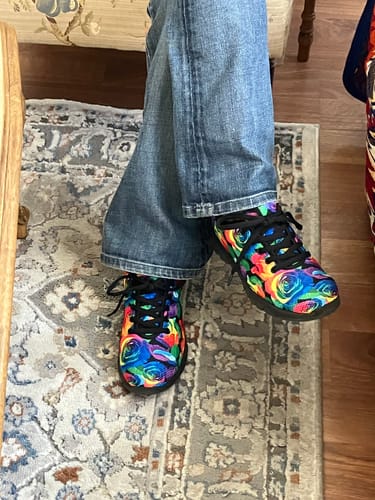 Customer wearing the vibrant Rainbow Roses running shoes with blue jeans.