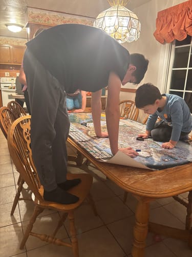 Reviewer's children using Dry Erase Markers on a large poster laid out on a dining table.