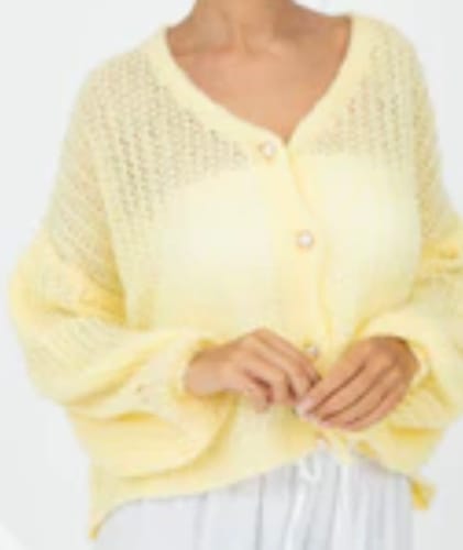 Ein Kunde trägt den hellgelben, flauschigen Feiner Lochstrick Cardigan mit Perlenknöpfen.