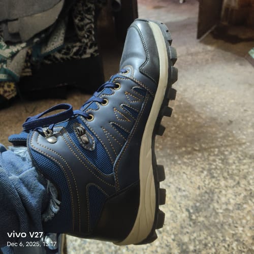 Customer wearing a blue Bacca Bucci Hunter boot with a thick treaded sole, viewed from the side.