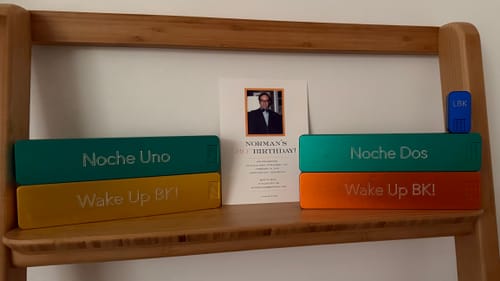 Customer's four personalized Weekly AM-PM Vitamin XL Cases displayed on a wooden shelf next to a birthday card.