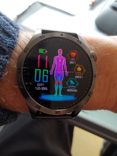 Rezensent mit der Herren Smartwatch EZ Pro am Handgelenk. Das Display zeigt ein farbenfrohes Gesundheits-Dashboard.