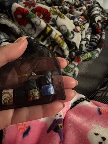 Customer holds the small, sheer Mini Subscription Bag, showing three fragrance samples inside.