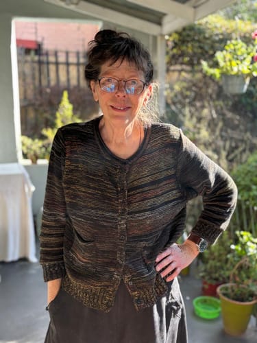 Reviewer standing outdoors wearing the vintage colorblock sweater with black trousers, which has dark horizontal stripes.