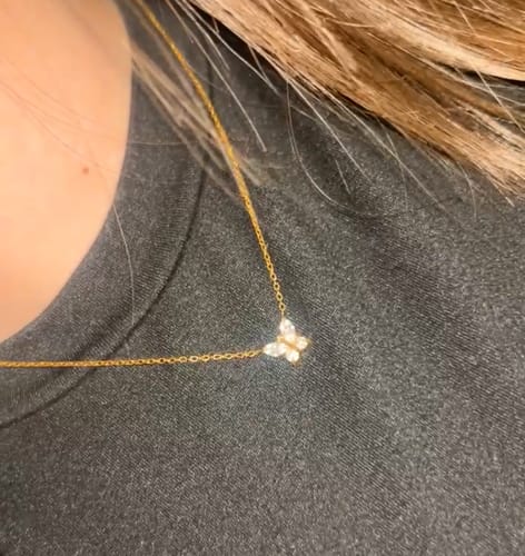 Kundin trägt die goldene Shine Butterfly Halskette mit dem funkelnden Schmetterlingsanhänger.