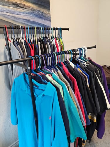 Reviewer's collection of colorful Ralph Lauren Polo Shirts hanging on two clothing racks.