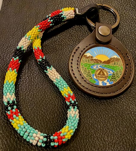 Reviewer's 6-month sobriety medallion in a leather keychain holder with a colorful beaded wristlet.