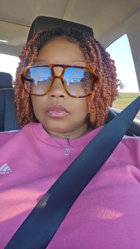 Reviewer wearing the short, ginger-colored Yanky Twist wig in a car.