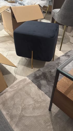 Customer's black velvet Gela Stool with slender gold legs sitting on a patterned rug in a room.