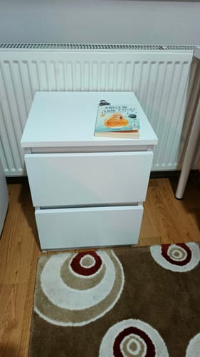 Müşterinin monte edilmiş, beyaz, iki çekmeceli Rani komodini bir odada duruyor.