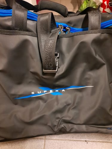 Recensent toont een close-up van een donkergrijze vistas met blauwe ritsen.