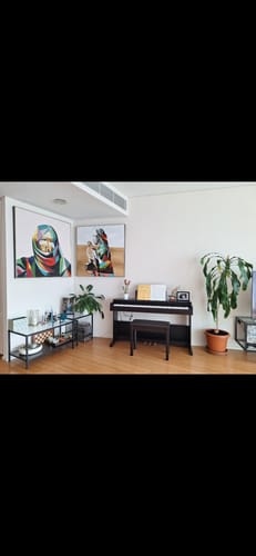Reviewer's two colorful Hand Painted UAE Culture Art Paintings displayed on a living room wall above a piano.