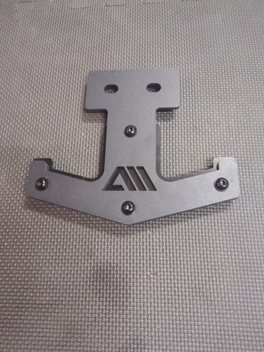 Ein Rezensent zeigt eine einzelne, graue Langhantel Ablage mit Logo, die auf einer strukturierten Matte liegt.