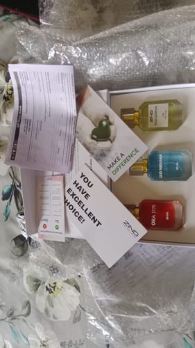 Customer's OUD Supreme BUNDLE, showing three colorful fragrance bottles inside their open box with packaging.
