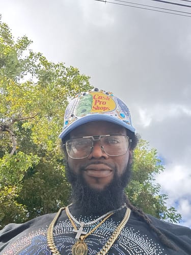 Customer wearing layered necklaces, showing off a prominent iced pendant.