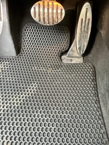 Zdjęcie od klienta pokazujące słabe dopasowanie czarnego dywanika samochodowego przy pedałach.