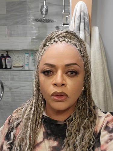 Reviewer with custom-blended Freetress Pre-Stretched Braids worn in a high half-up, half-down style.