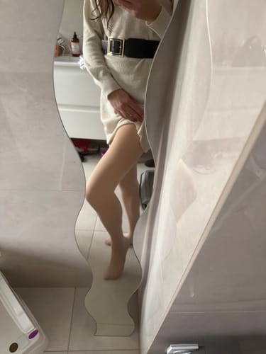 Cliente portant le collant polaire beige effet transparent sous une robe pull.