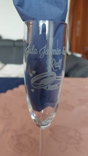 Kunde zeigt ein Leonardo Sektglas mit personalisierter „Wedding“-Gravur von Namen und Ringen.