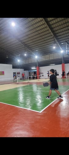 Reviewer on an indoor court wearing the black adidas Ligra 8 Indoor Sports Shoes for a game.