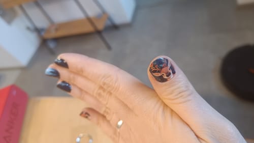 Rezensentin zeigt die 'Cute Wonderland' Nagelfolie mit einem detaillierten Rentier-Design auf dem Daumen.