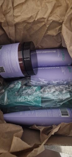 Un client montre les produits de la Routine essentielle nutrition & fortification dans leur carton de livraison.