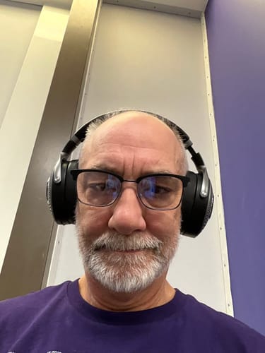 A close-up photo of a customer wearing the black Focal Bathys Headphones.