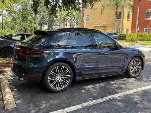 Customer's dark blue SUV parked, with 80Eighty® Valve Stem Caps installed on the wheels.