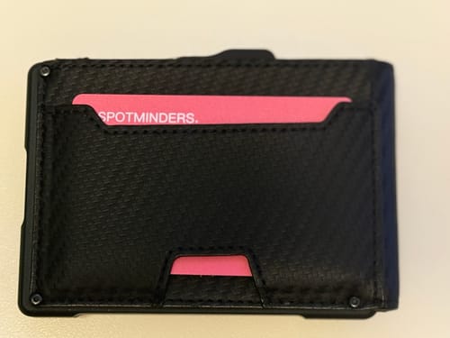 Customer's pink SPOTMINDERS. Tracking Card shown inside a black wallet, demonstrating its slim fit.