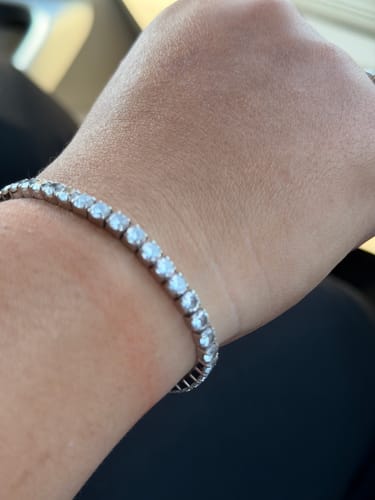 Close-up of a reviewer wearing the sparkling Silver Signature Tennis Bracelet on their wrist.