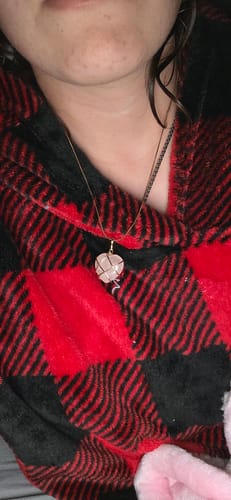 Close-up of a customer wearing a wire-wrapped, heart-shaped crystal necklace from the VIP Crystal Club.