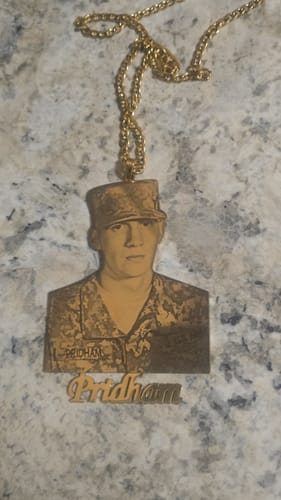 Customer's custom photo engraved pendant necklace with a portrait of a soldier and the name 'Pridham' below.