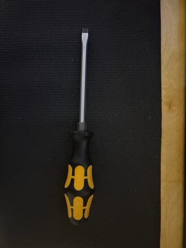 Reviewer's Wera slotted screwdriver showing its steel shaft and black and yellow handle.