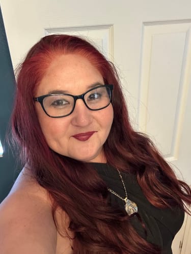 Reviewer shows her long, vibrant red hair after using the Instant Dye Shampoo, highlighting the brighter color on her roots.