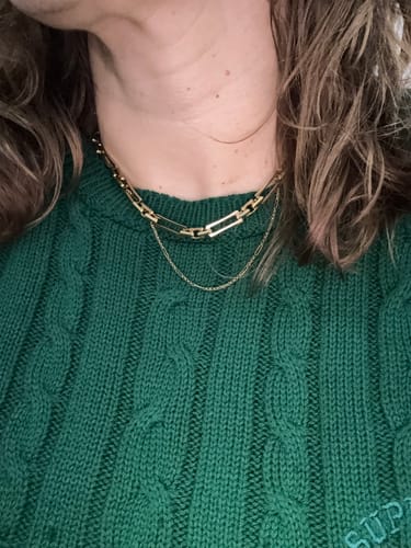 Close-up of a reviewer wearing the elegant Lovers Chain Necklace, layered with another thin chain against a green knit sweater.