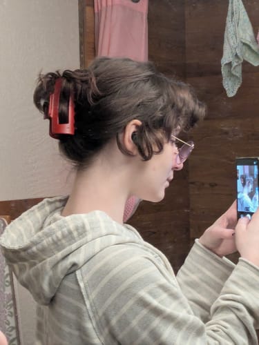 Reviewer's profile view showing a red cloud clip securing their hair in a casual updo.