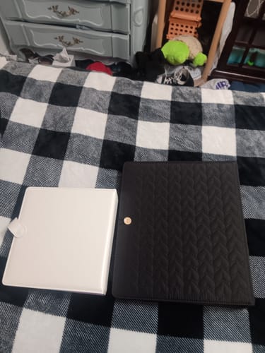 Reviewer's two Cupid's Collection A4 binders, one white and one black with a quilted design, on a checkered blanket.