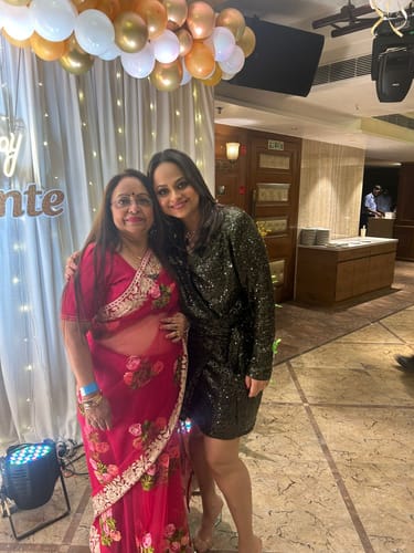 Customer wearing the Red Floral Embroidered Net Saree at a festive event with another person.
