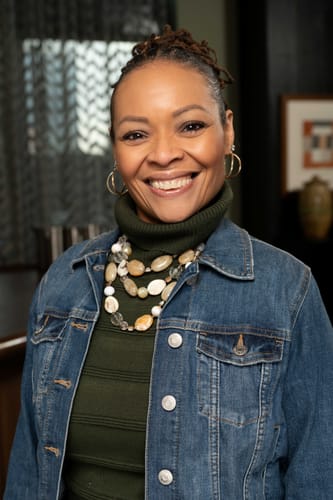 Customer with glowing, moisturized skin smiles while reviewing The Awakening 4 Piece Treatment System.