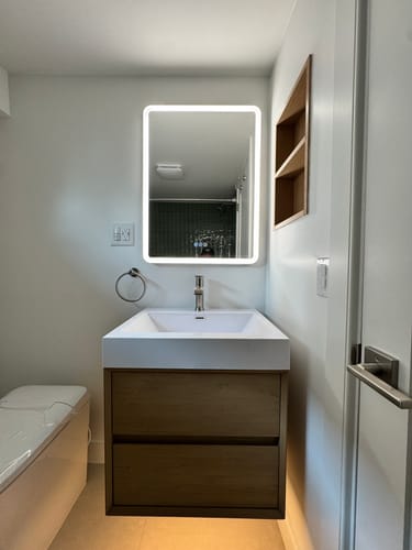 Customer's Maslow Floating Vanity with a warm wood finish and white top, installed in a modern bathroom.