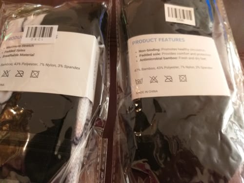 Recensentens närbild som jämför etiketterna på två olika förpackningar av Diasocks Komfortstrumpor.