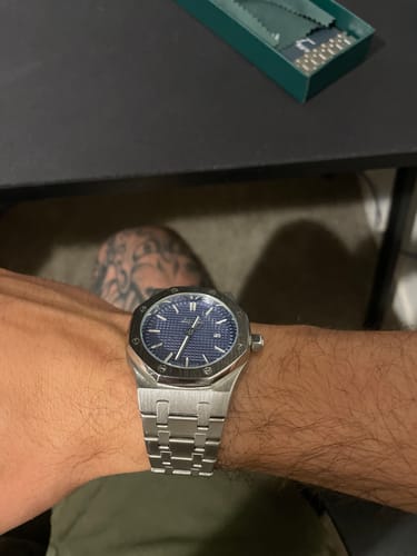 Customer's silver Lucky Fours® Oceanus watch with a textured blue dial, worn on their wrist.