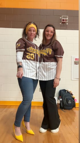 Two reviewers wearing matching personalized brown and white half-stripe baseball jerseys.