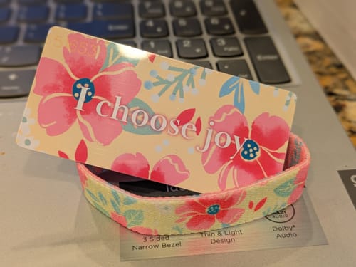 Reviewer's I Choose Joy Bracelet and matching floral card with 'I choose joy' text on a laptop.